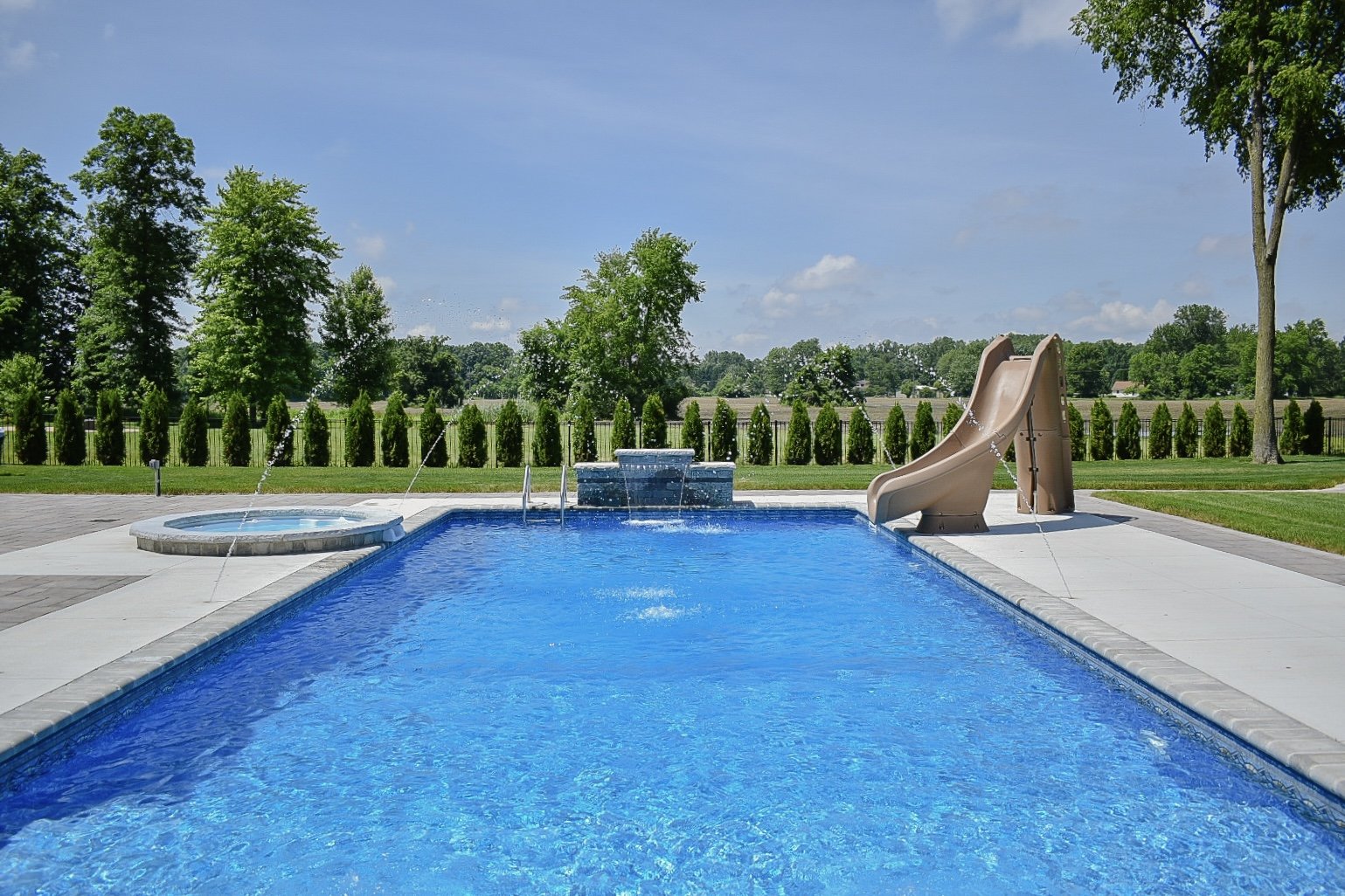 Fire pit lounge area surrounded by custom paver patios and professionally installed landscape plantings — GLC Lawn & Landscape