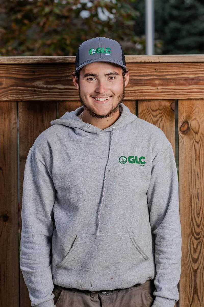 Justin, Lawn Maintenance Team Lead, in a gray GLC hoodie and cap — GLC Landscaping & Pools