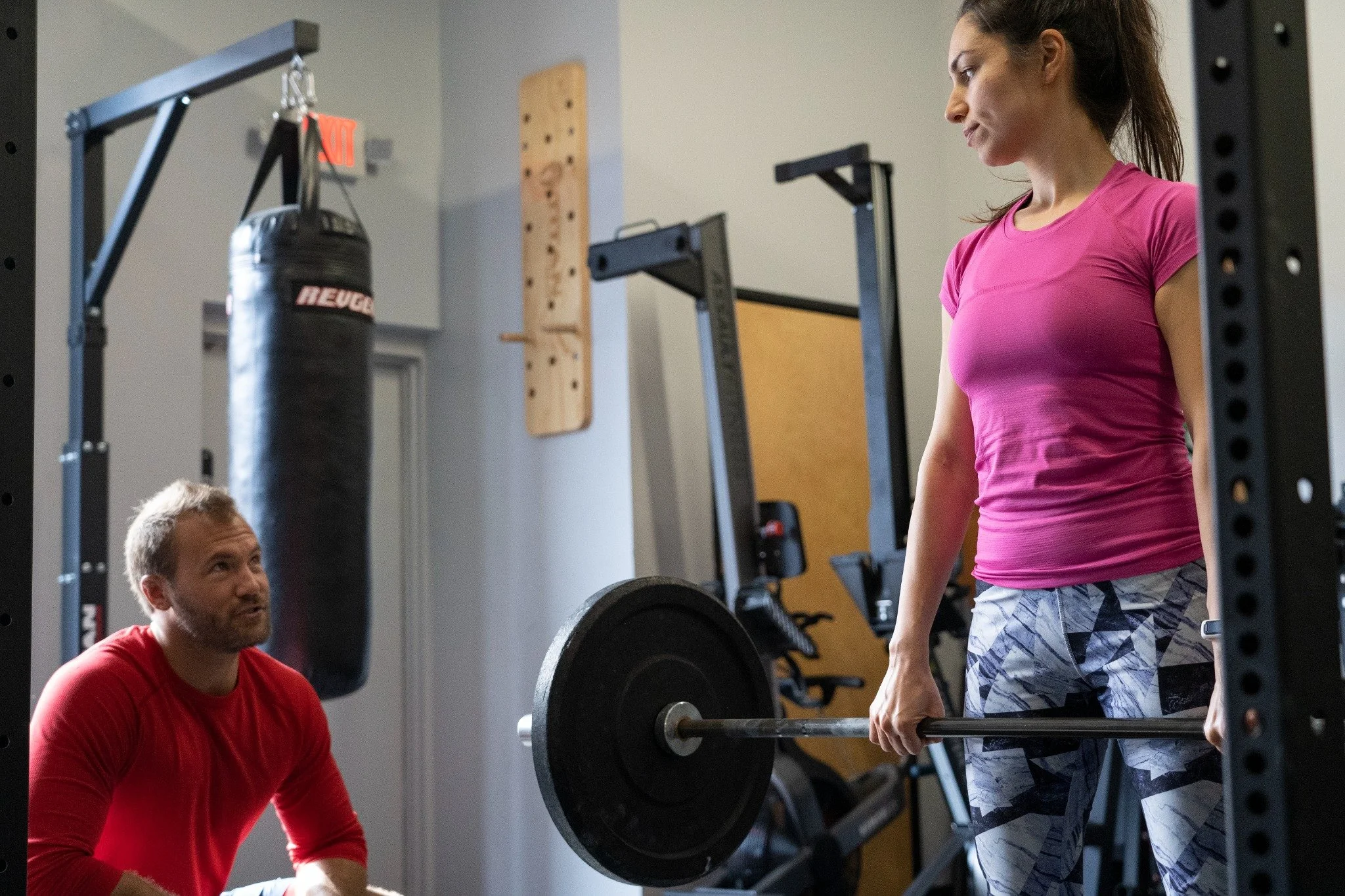 Michael Bann coaching a client during barbell training