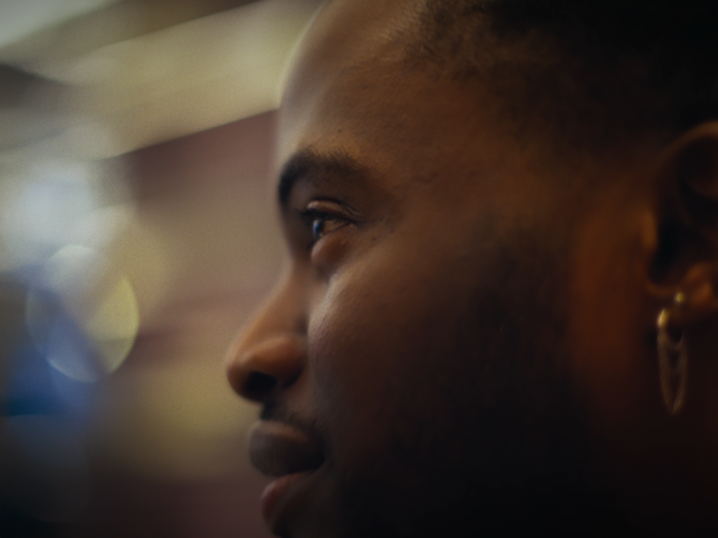 Close-up profile of a young person's face with a blurred background.