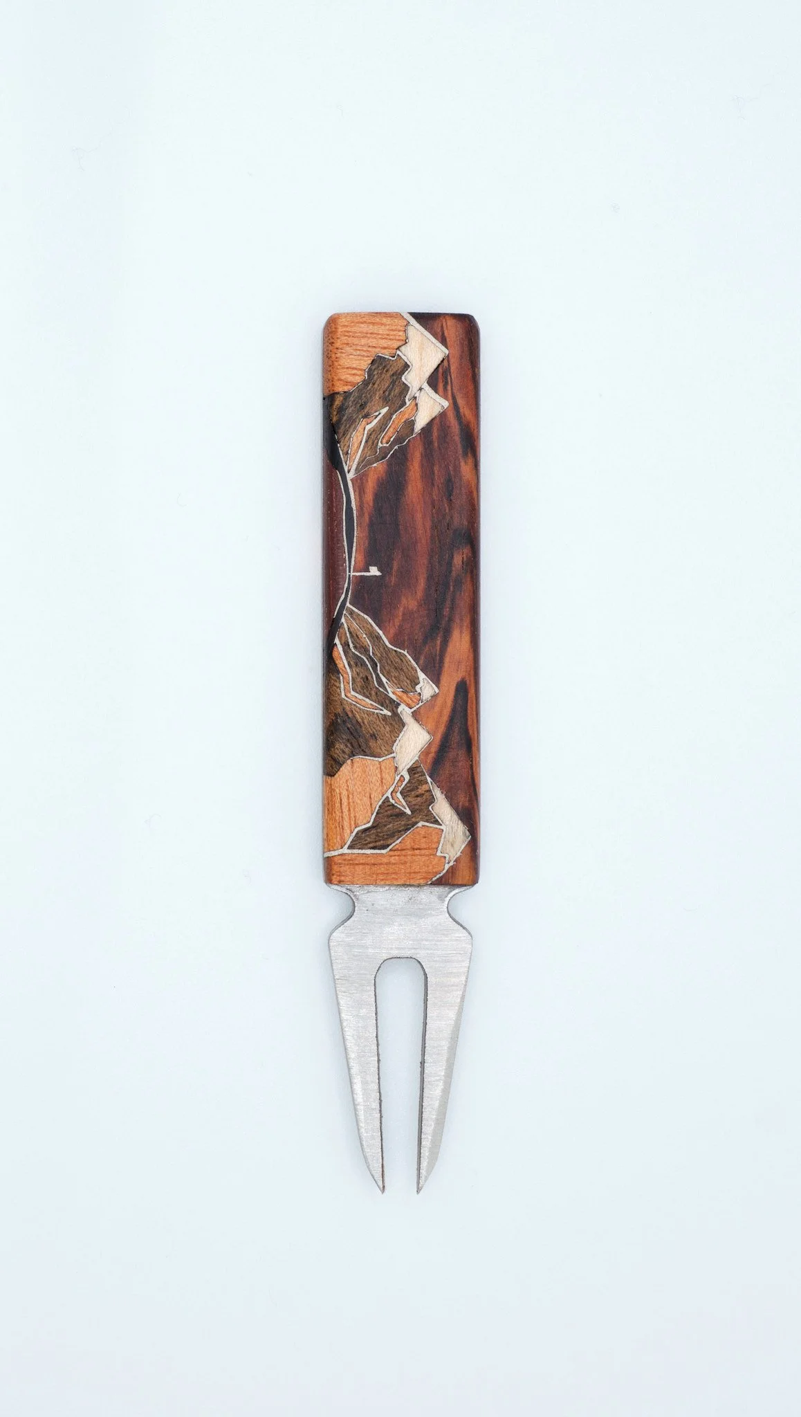 A small wooden fork with a decorative handle featuring a mountain landscape design with a golf flag and green.