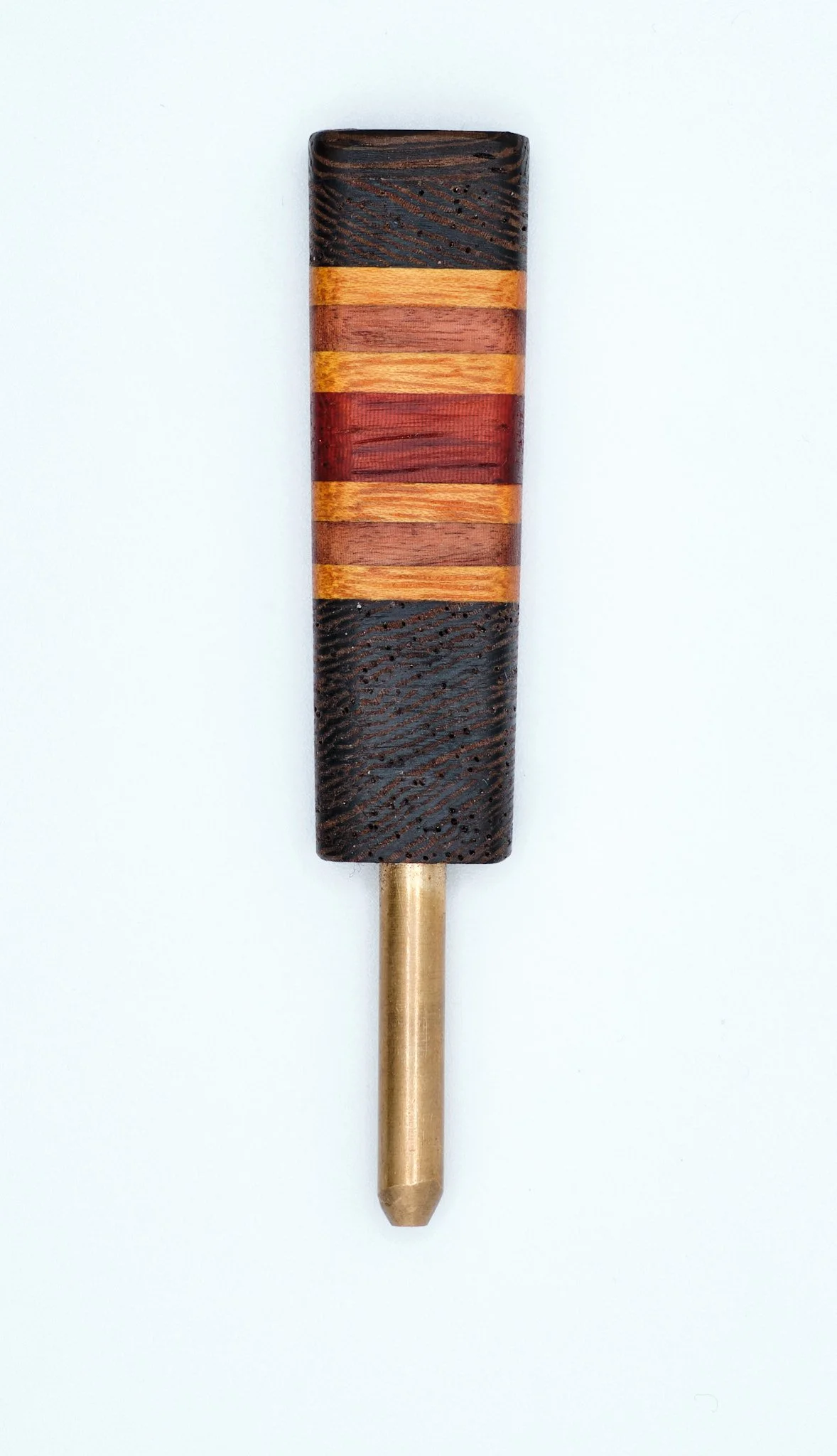 A wooden tool with a engraved handle and a brass tip, resembling a chisel.
