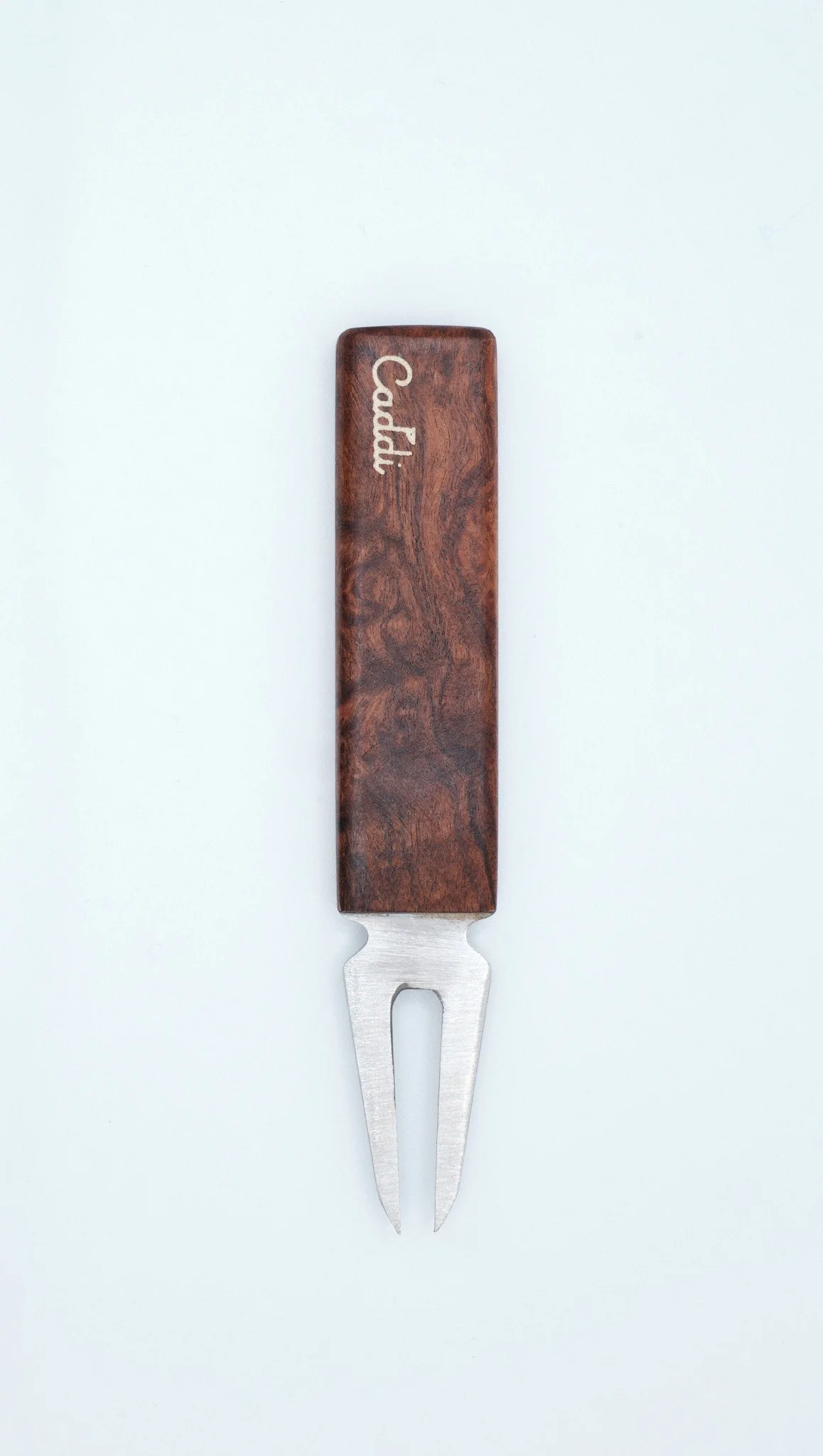 A wooden handle fork with the brand name 'Cadil' engraved on it.