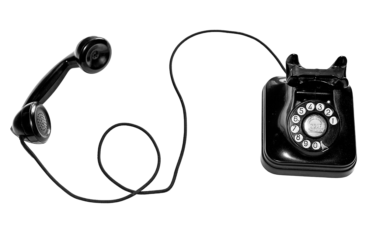 Black rotary dial telephone with handset resting on a mirrored surface.