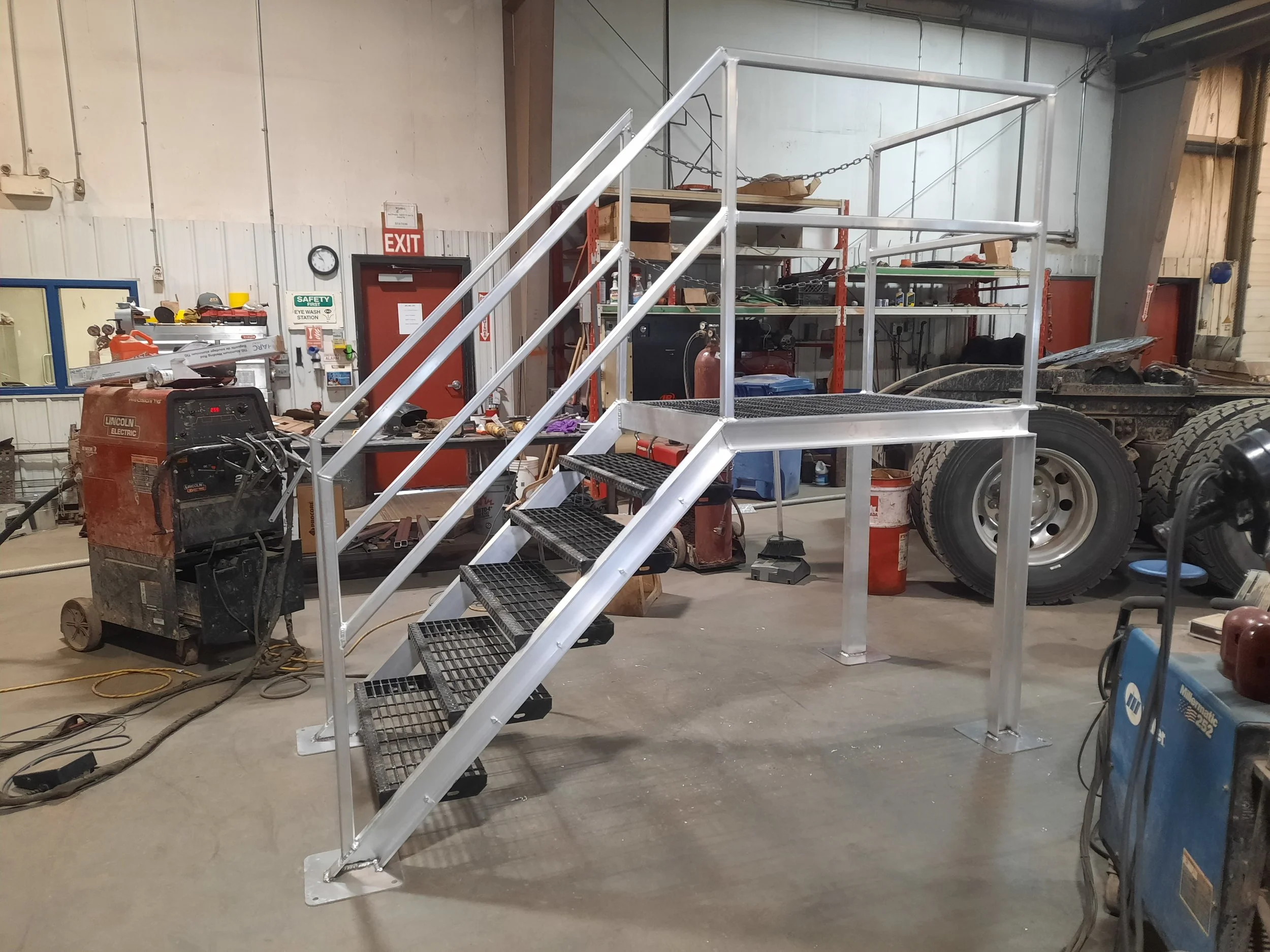 Industrial metal work platform with stairs inside a workshop.