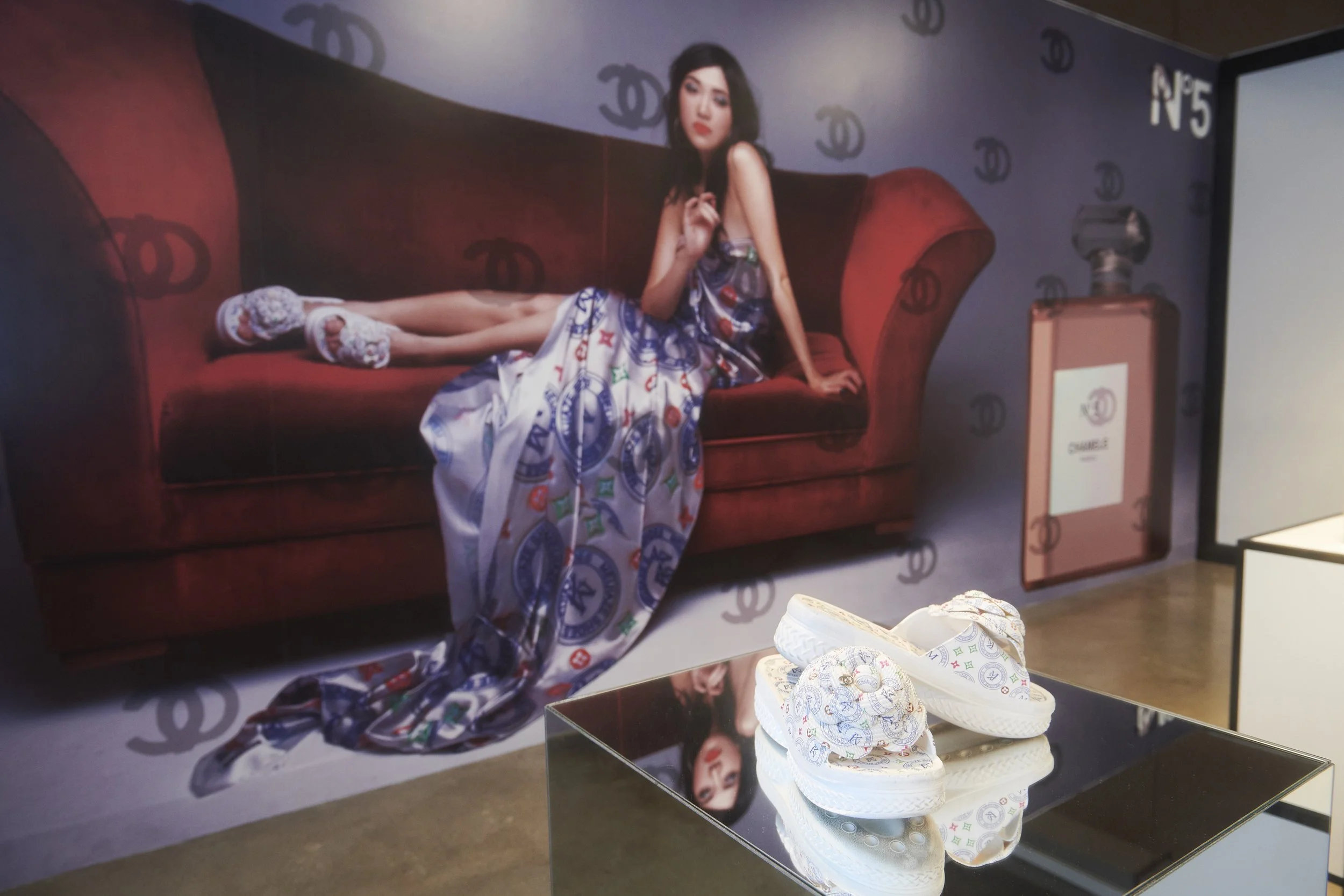 Background: "Wallpaper" as part of "Gloss", 2019, colour digital print on vinyl wallpaper, 650 cm x 298 cm. 
Foreground: "Platform,"  wig, digital print on satin: 54 in x 108 in, Found object, shoes: women’s size 37, mirror plinth: 94.5 cm x 50 cm x 