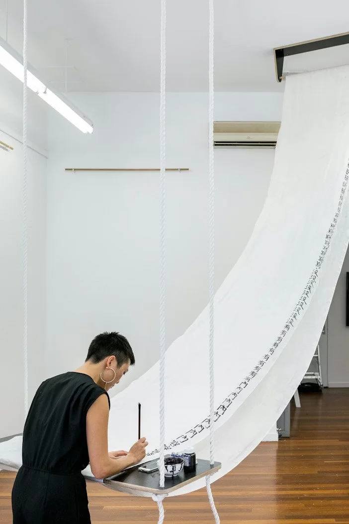 Rainbow Chan performing as part of "To enclose one’s mouth", 2017, ink, silk, wood, video loop, dimensions variable."Moth Cape: Big Crybaby" 2020, silk dye on silk, cotton thread, diamantes.