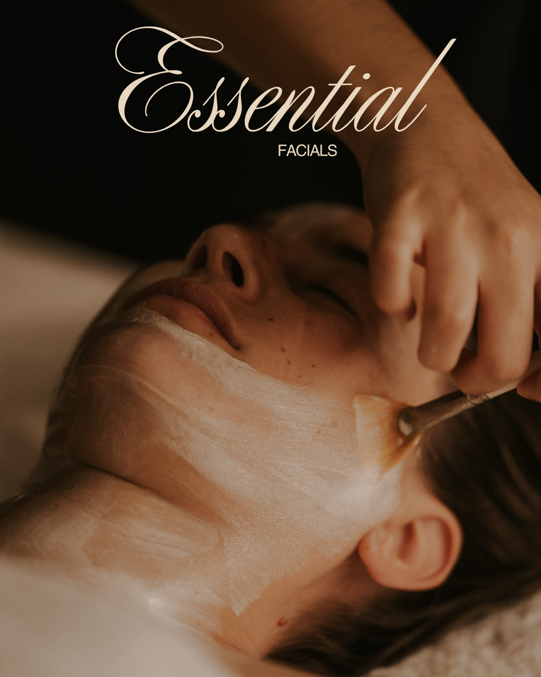 Person receiving a facial treatment with a brush applying a facial mask.