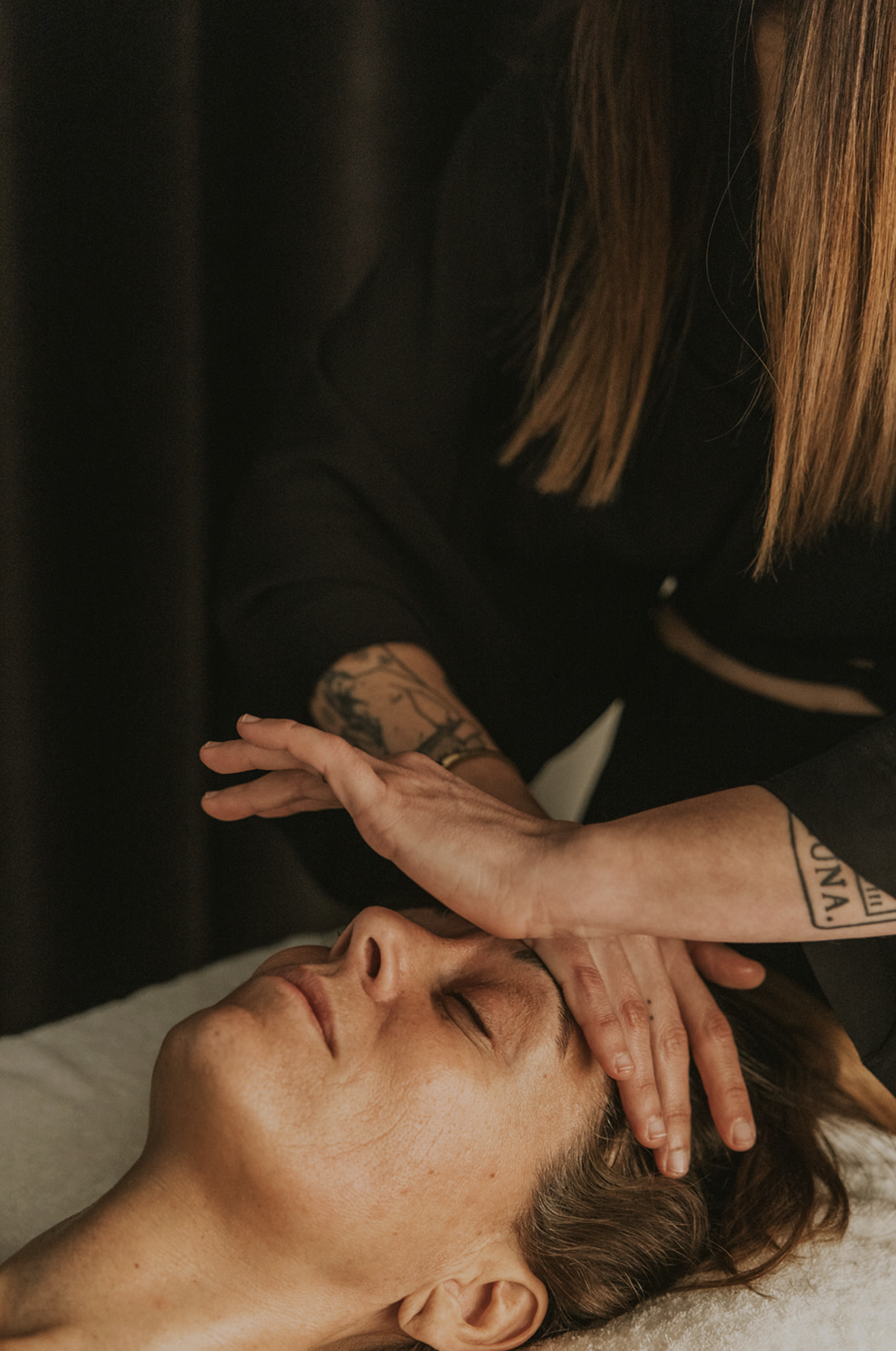 A person receiving a facial massage from a massage therapist