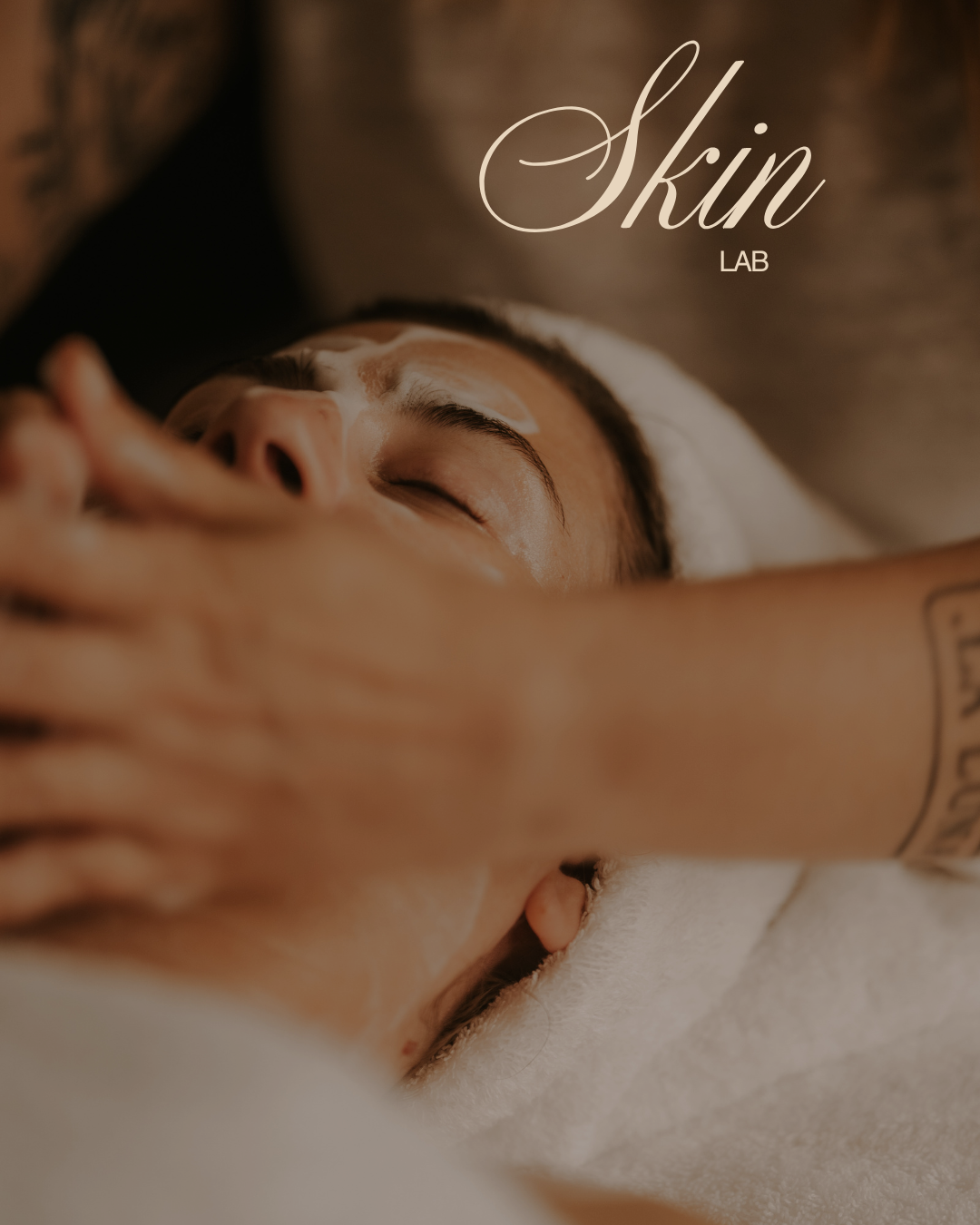 A woman receiving a facial treatment, with skincare products applied to her forehead, while lying on a spa bed.