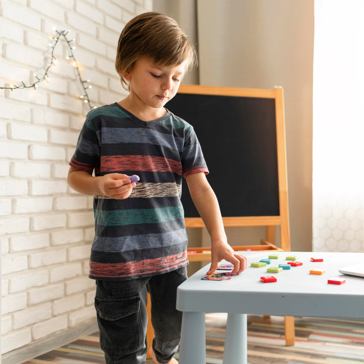 Child practicing early literacy and learning through interactive games with a trusted babysitter in the Main Line area.
