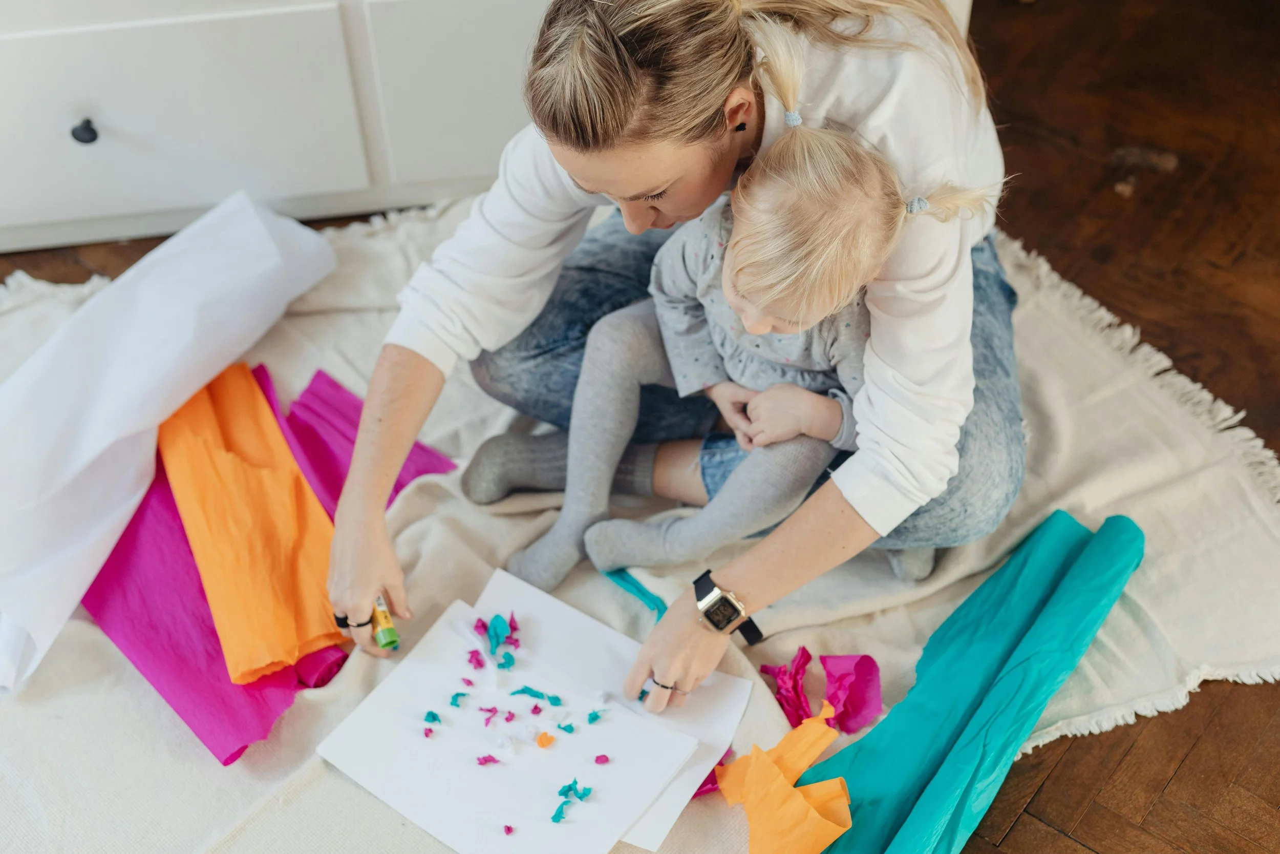 Babysitter and child creating colorful arts and crafts together, encouraging creativity, fine motor development, and hands-on learning.