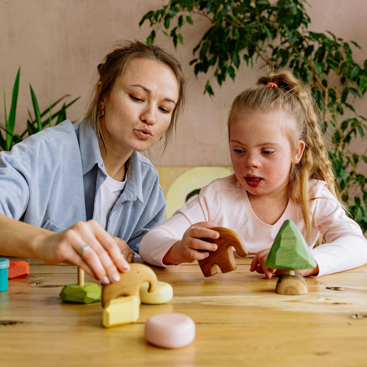 Babysitter and young child building developmental skills through interactive play with wooden stacking toys in a nurturing home environment.