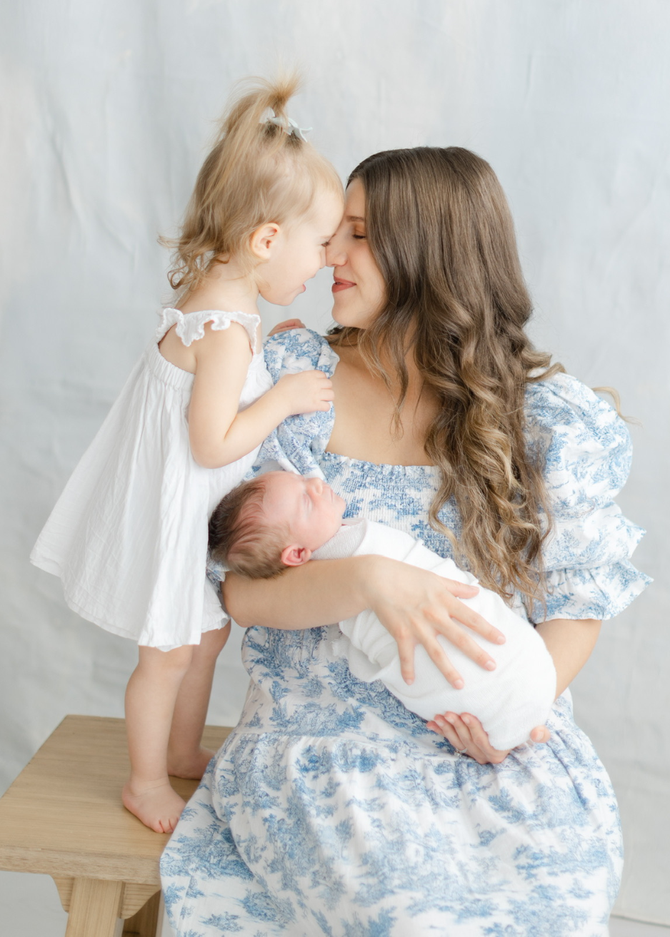 Owner of Balanced Babysitting sharing a heartfelt moment with a newborn and young child, reflecting compassionate, family-centered care for families throughout the Main Line and Chester County, PA.