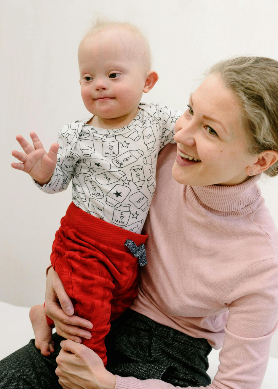 Smiling caregiver holding toddler in Main Line, PA, providing nurturing and personalized childcare support through Balanced Babysitting.