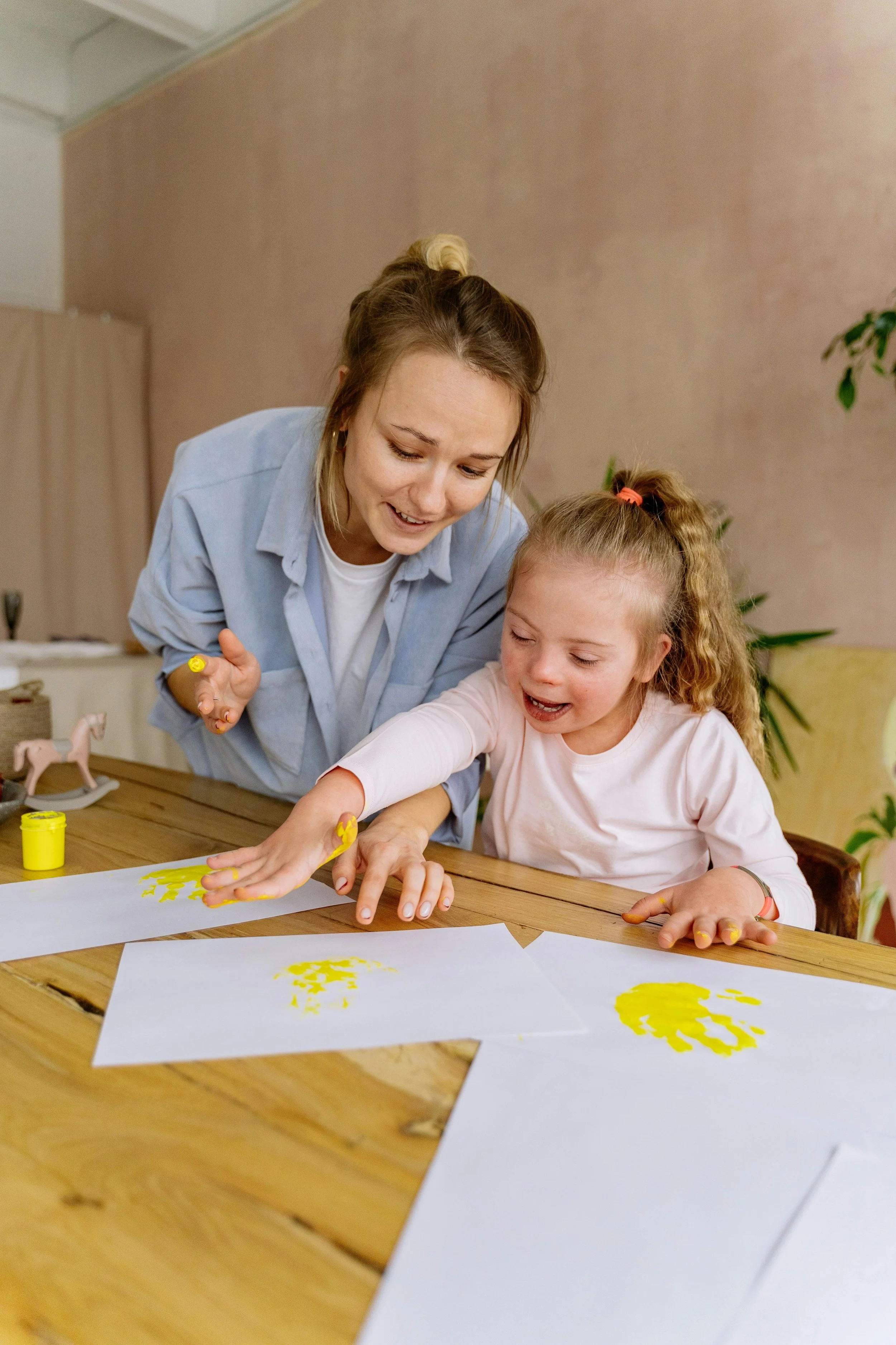 Caregiver and child creating finger paintings together, encouraging creativity, self-expression, and meaningful learning experiences for Main Line and Chester County families.