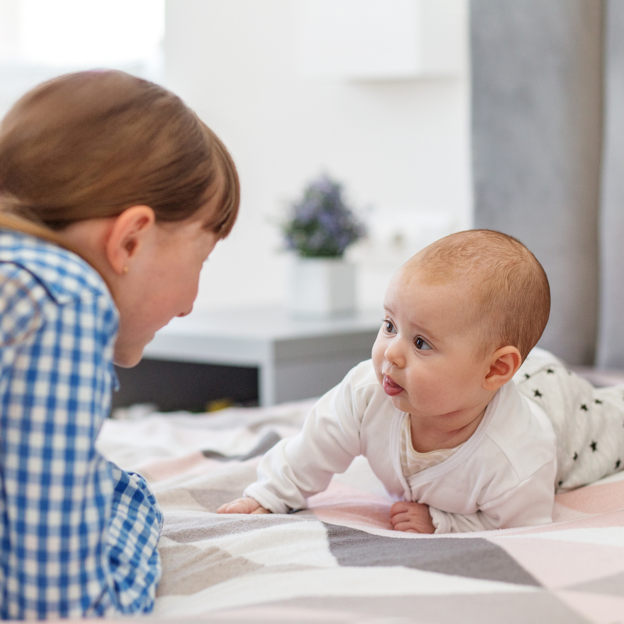 Caregiver engaging with an infant through responsive, attentive interaction, supporting healthy development and bonding for families in Chester County and the Main Line.