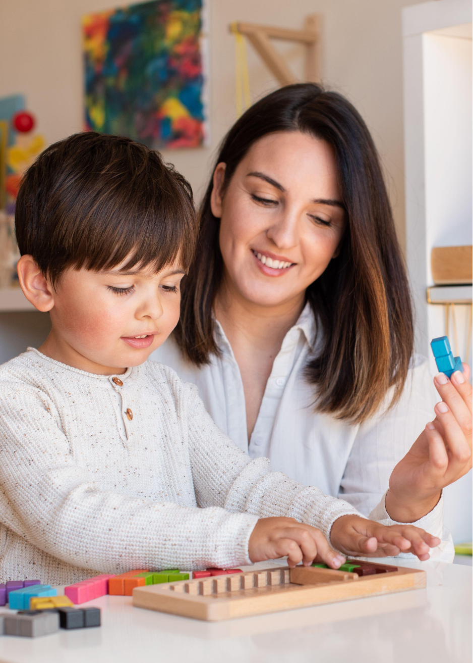 Caregiver and child engaging in educational play with colorful learning toys, supporting early childhood development and meaningful family connections in Chester County and the Main Line.