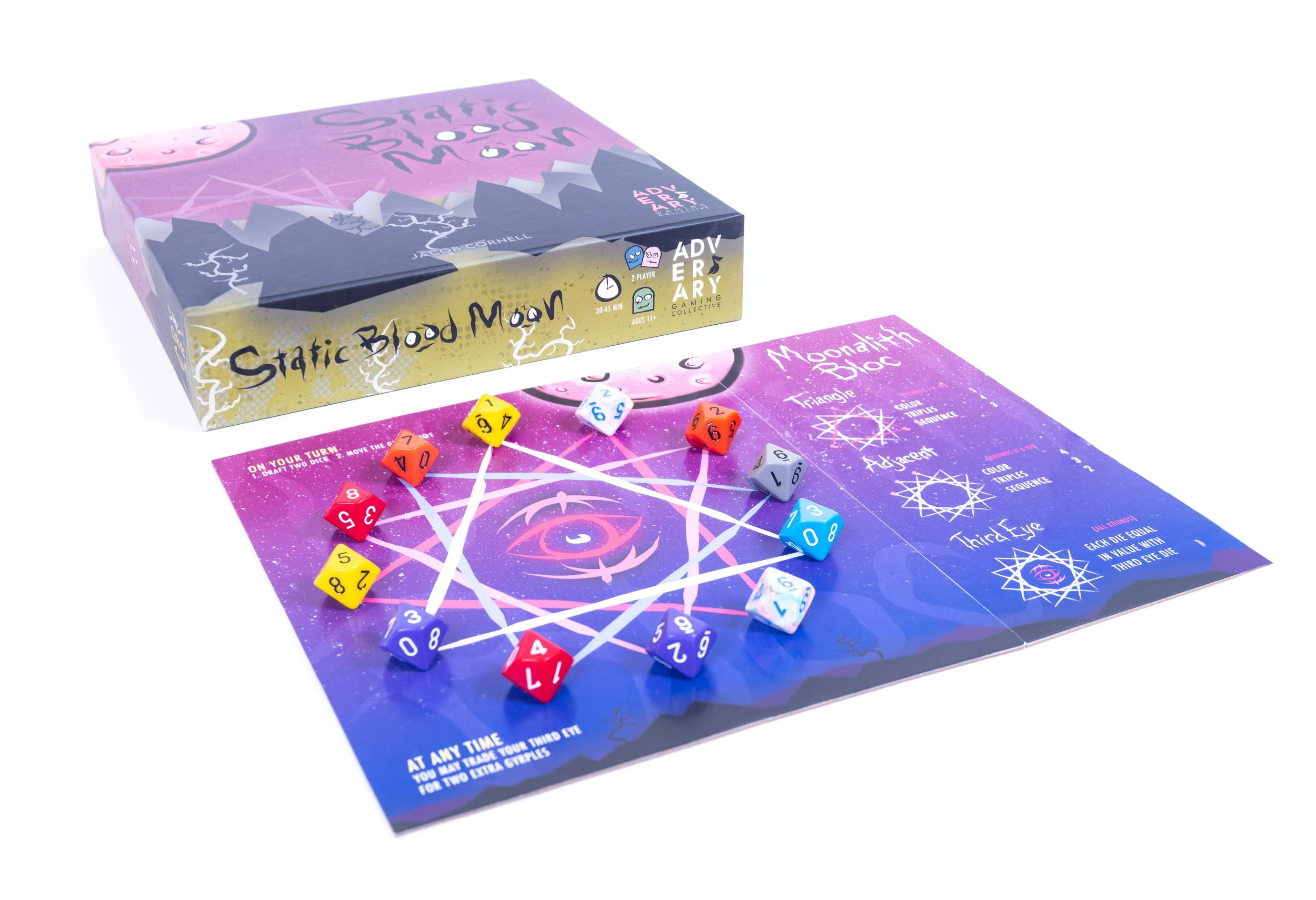A board game called 'Static Blood Moon' with game pieces and instructions, and the game box showing a mountain scene with trees and lightning bolts.
