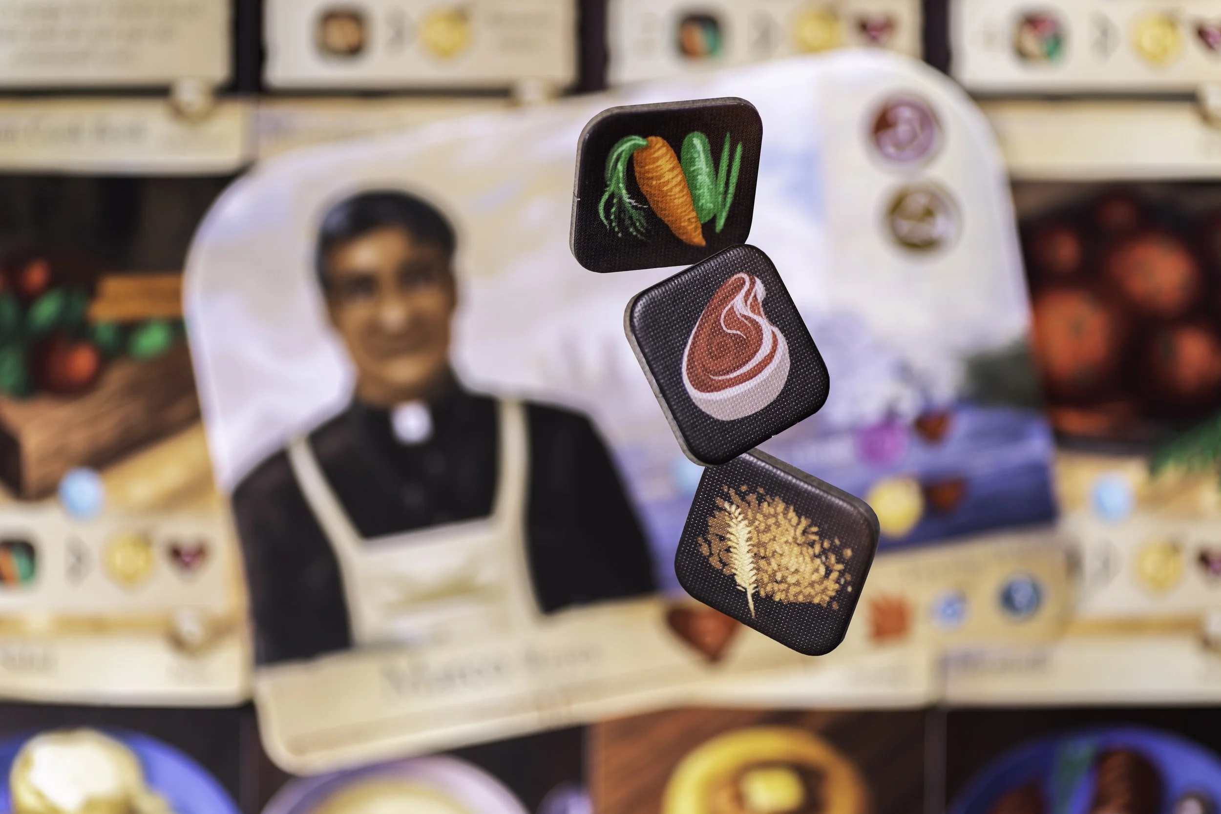 Close-up of three small square icons with various food symbols, floating above a blurred background of a person in clerical attire with a broad smile, and a display of colorful food packages.