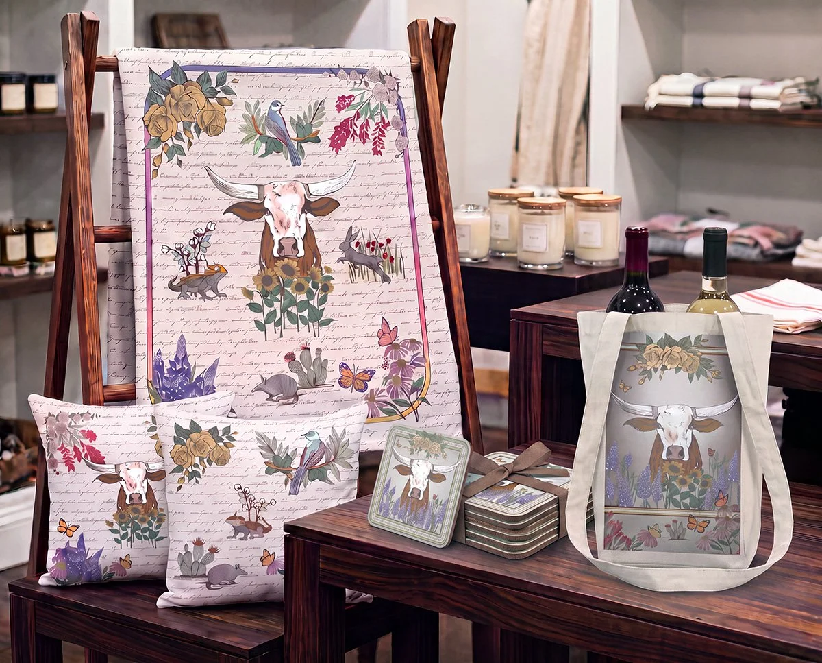 Texas Lone Star Wilds wholesale display featuring silk scarf, wine tote, pillows, blanket, art cards, coasters, and coordinating home décor.