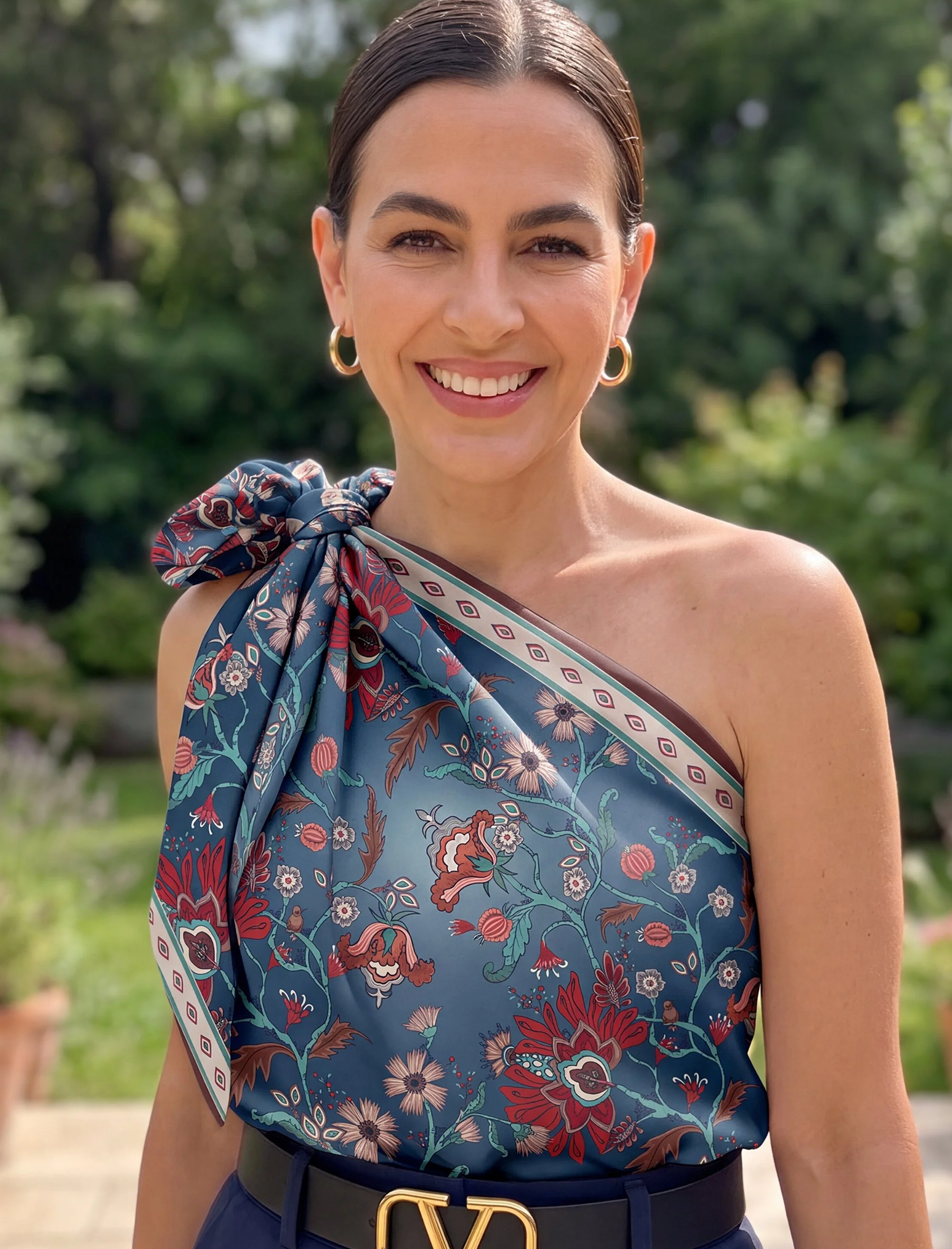 View Gilded Retreat press materials featuring a woman wearing the richly colored ornamental garden silk scarf.