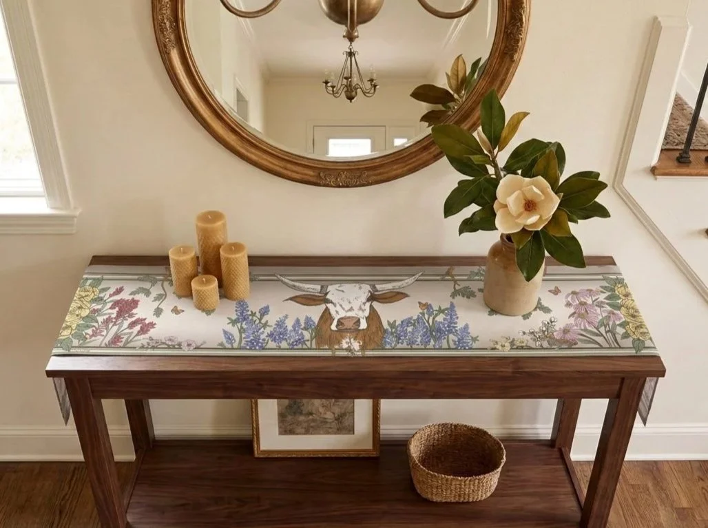 Texas Lone Star Wilds cotton table runner styled on an entry console with magnolias, candles, and hand-drawn longhorn artwork.