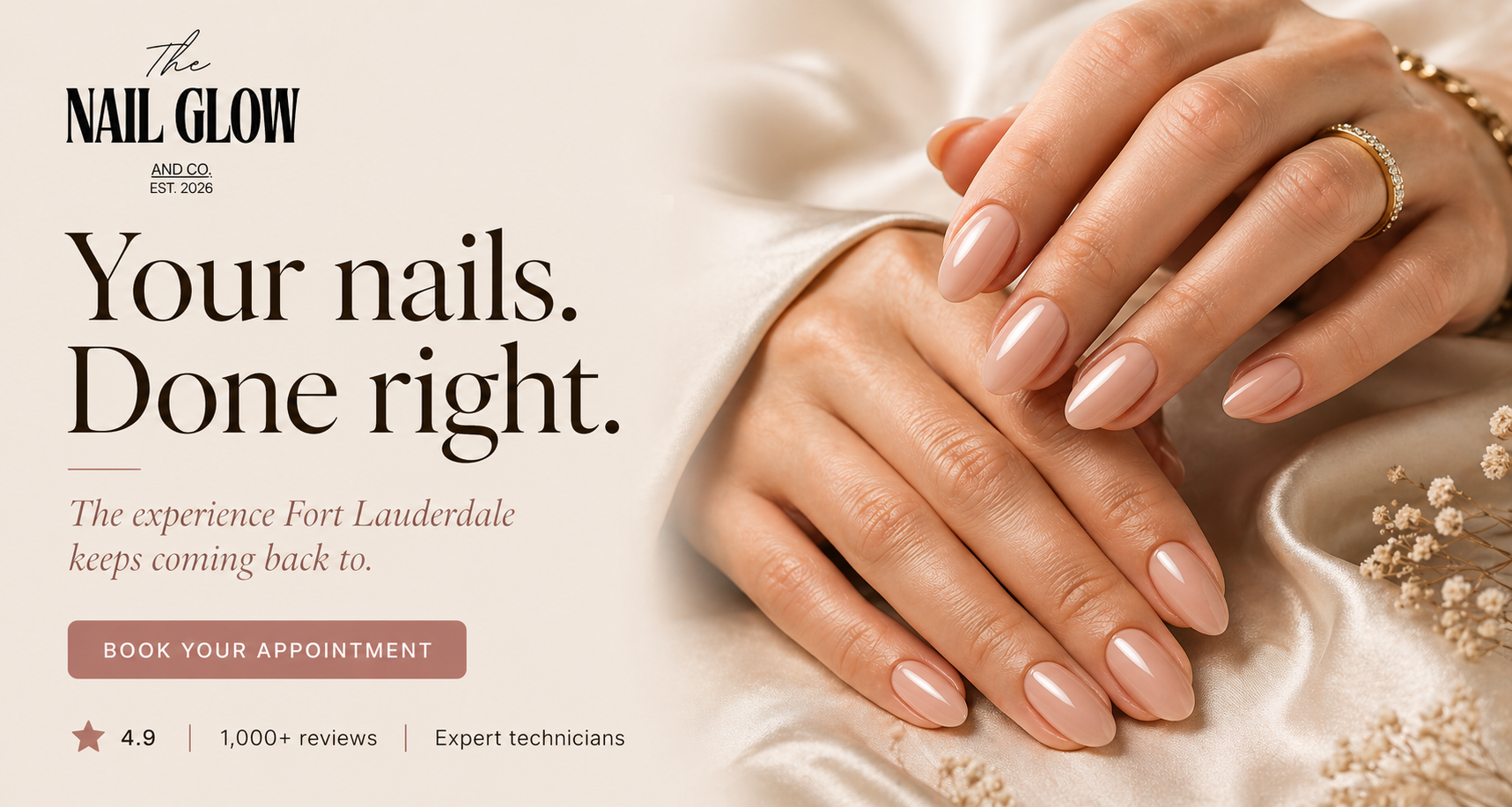 Close-up of well-manicured hands with nude polish, adorned with rings, resting on satin fabric with small flowers, advertising a nail salon called The Nail Glow.