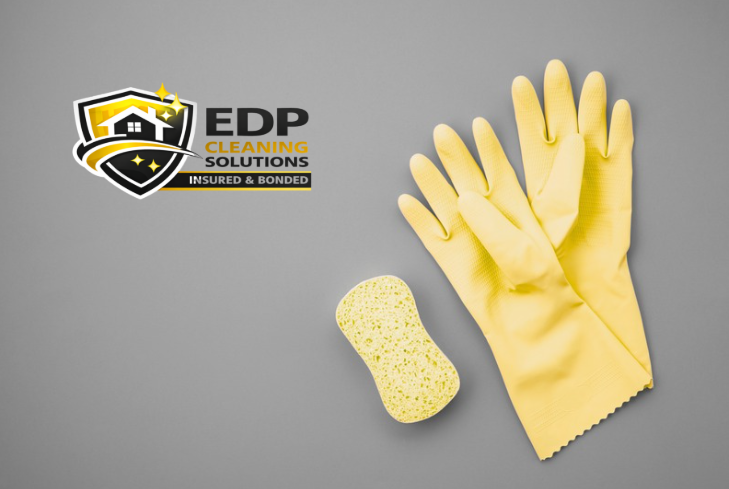 Pair of cleaning gloves next to a sponge for professional residential and commercial cleaning services.