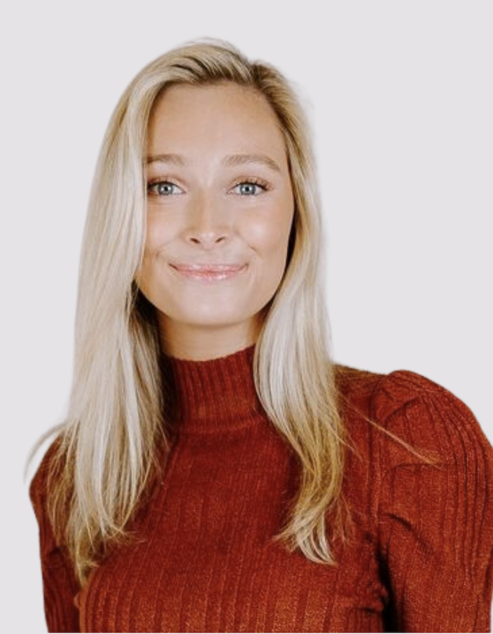 A young woman with blonde hair smiling outdoors.