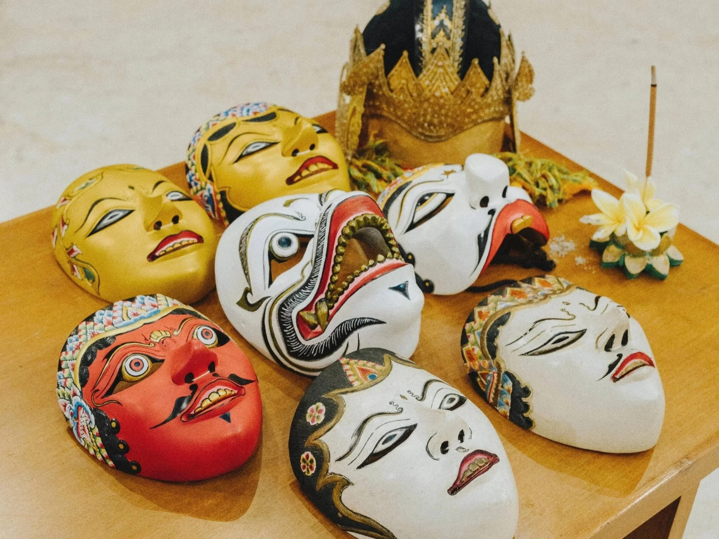 A display of traditional Javanese decorative & cultural masks on a wooden table - Premium Indonesian Green Coffee Beans Exporter