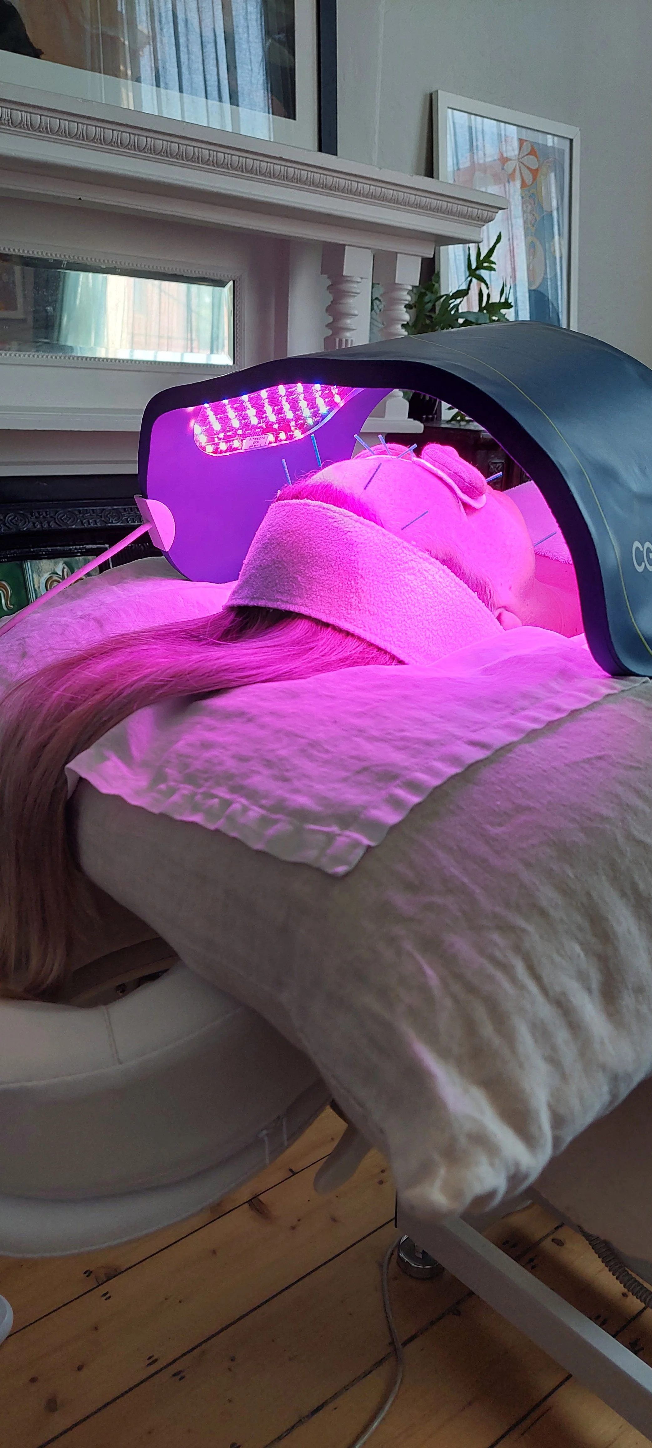 Facial acupuncture patient relaxes with LED therapy