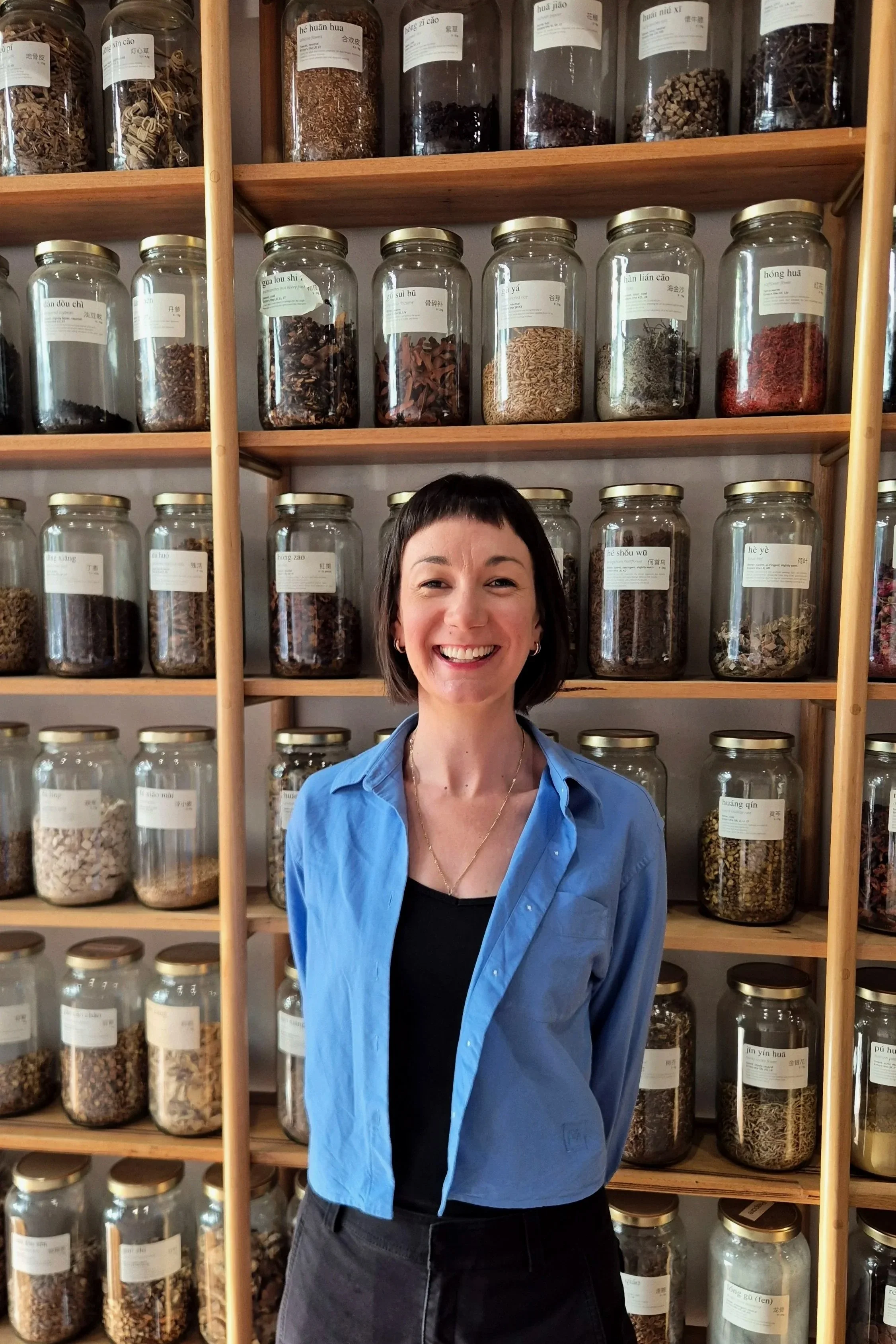 Smiling practitioner in a herbal dispensary