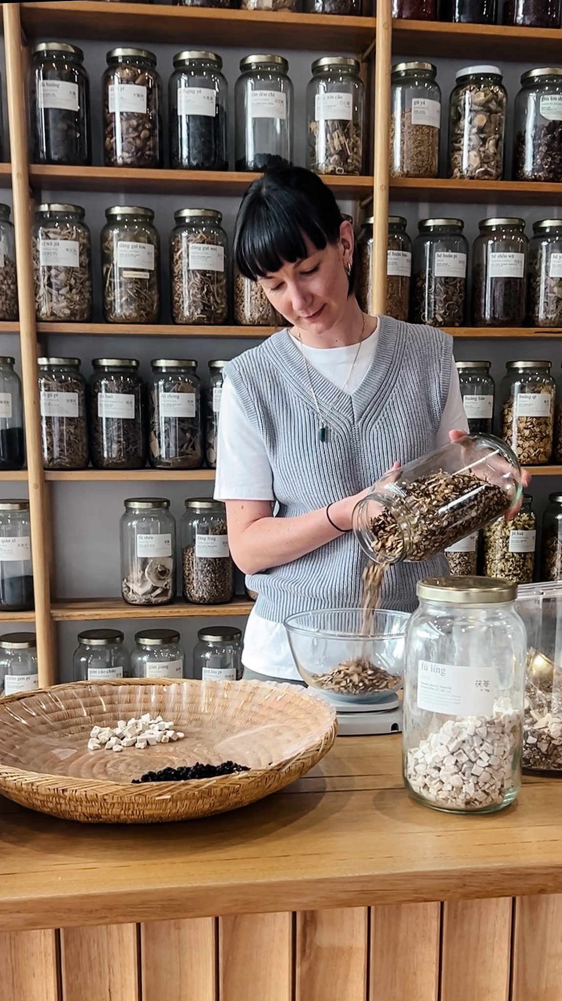 Practitioner weighing Chinese herbs on a scale.