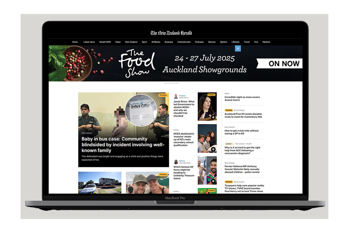 Laptop displaying the homepage of The New Zealand Herald website, featuring news articles and headlines.