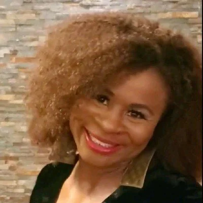 Headshot of a Black woman with curly hair