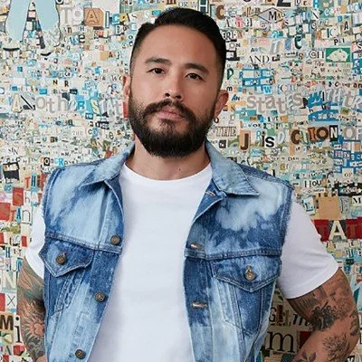 Headshot of an Asian man with short black hair and a beard
