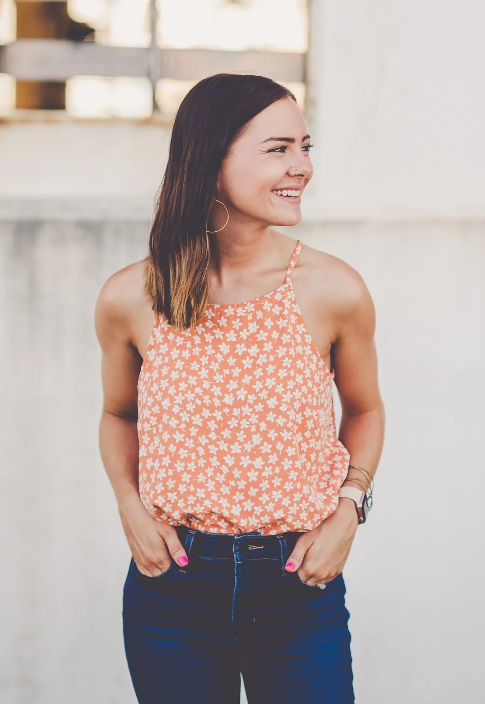 Photo of a white woman with brown hair smiling away from the camera