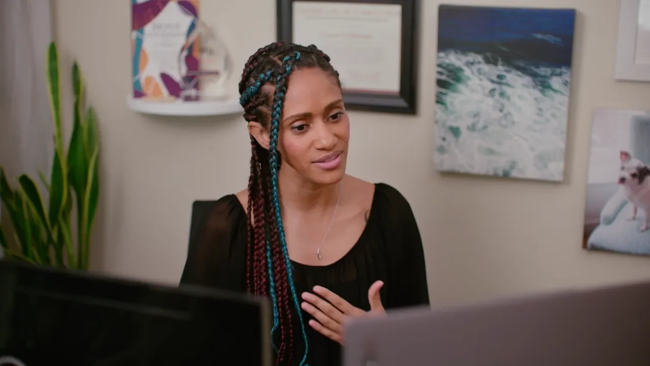 Photo of a black woman looking at a computer 
