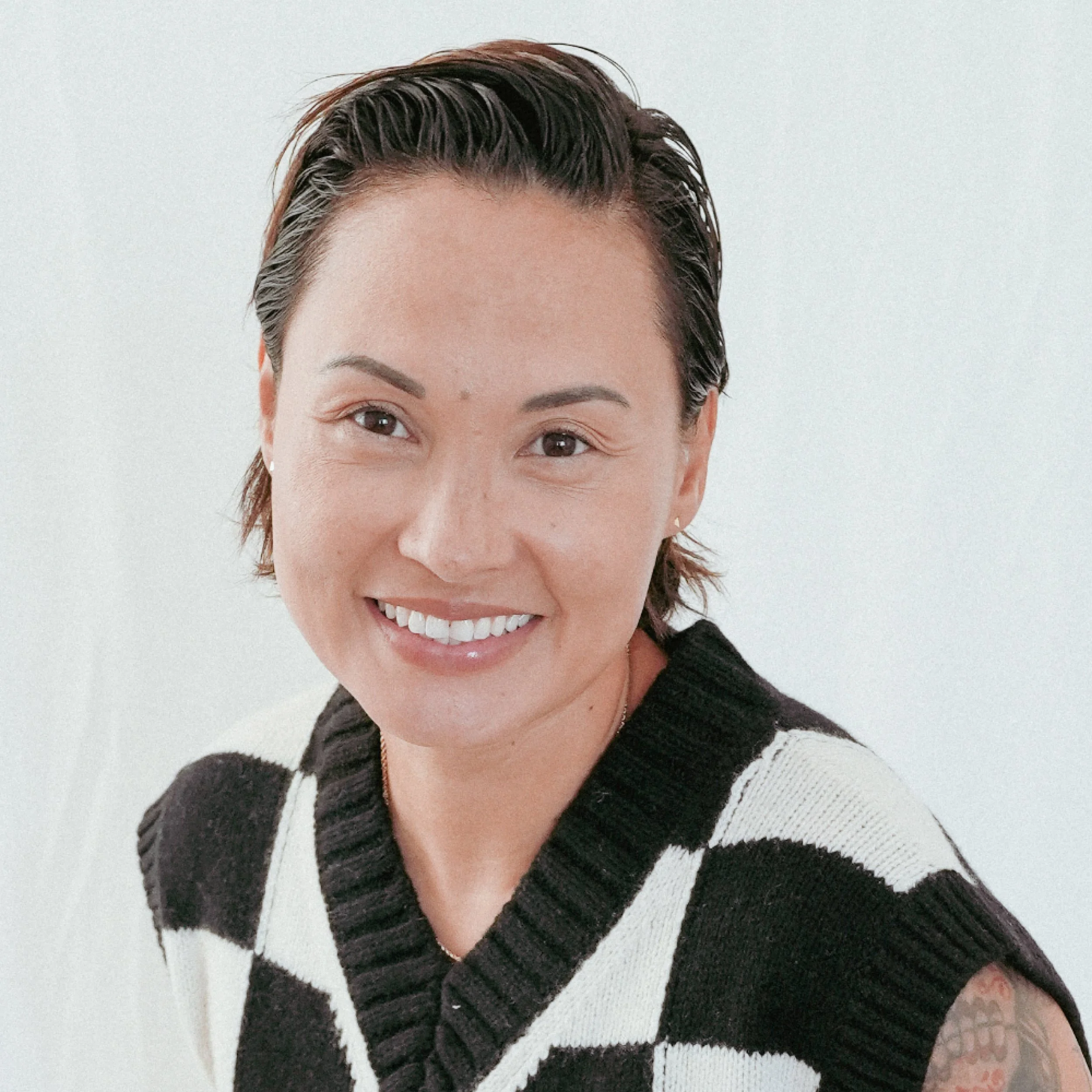 Headshot of a mixed race Asian/Latin woman with short black hair, smiling