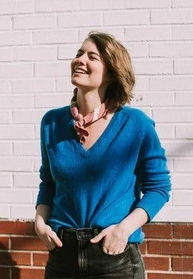 Photo of a white woman with short light brown hair smiling away from the camera