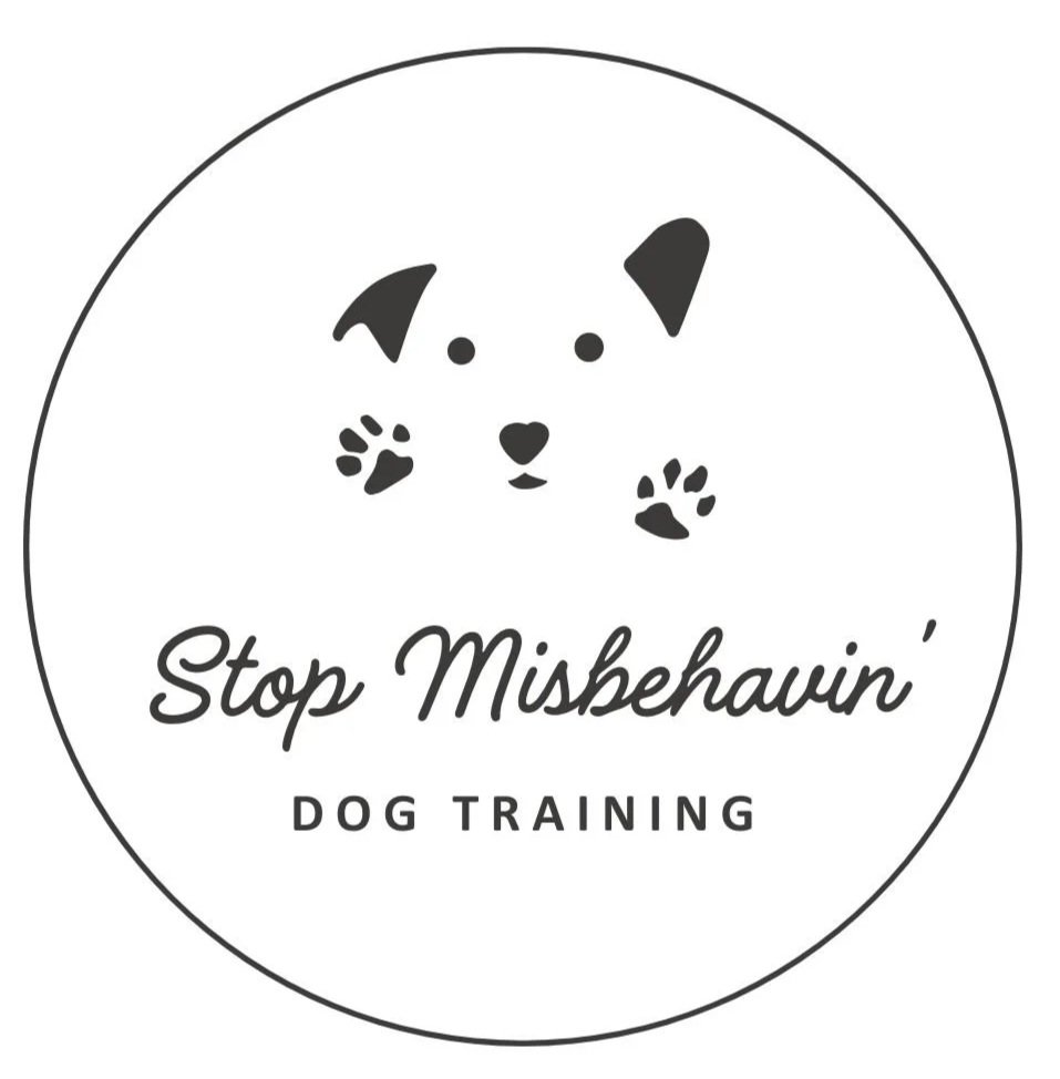 A circular logo with a simple cartoon dog face above the text 'Stop Miskehavin' Dog Training' in black.