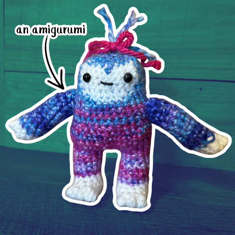 A crochet amigurumi of a Bigfoot with a bow in its hair