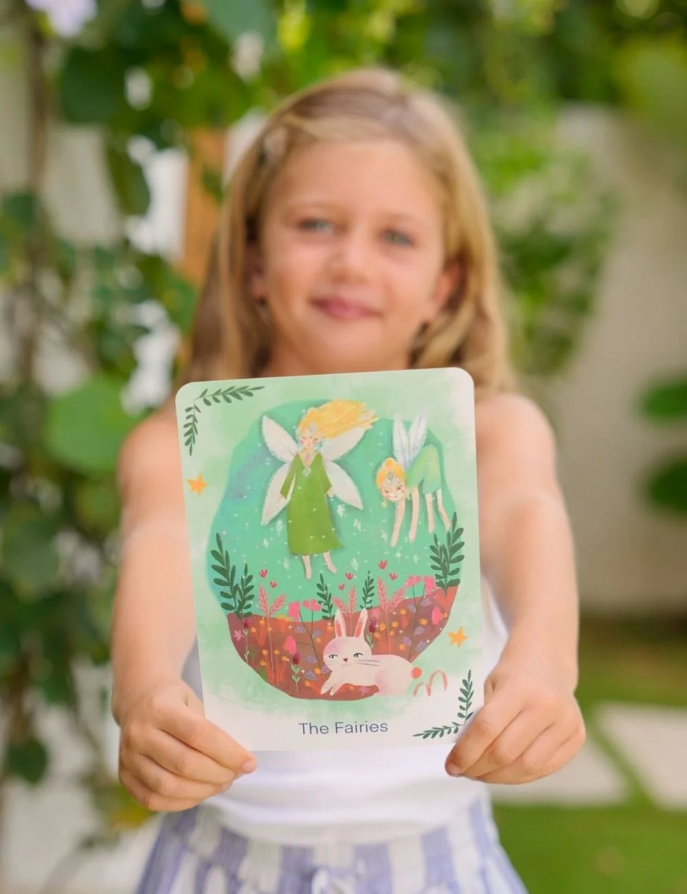 Young girl holding a Little Lightworkers mindfulness card called The Fairies.