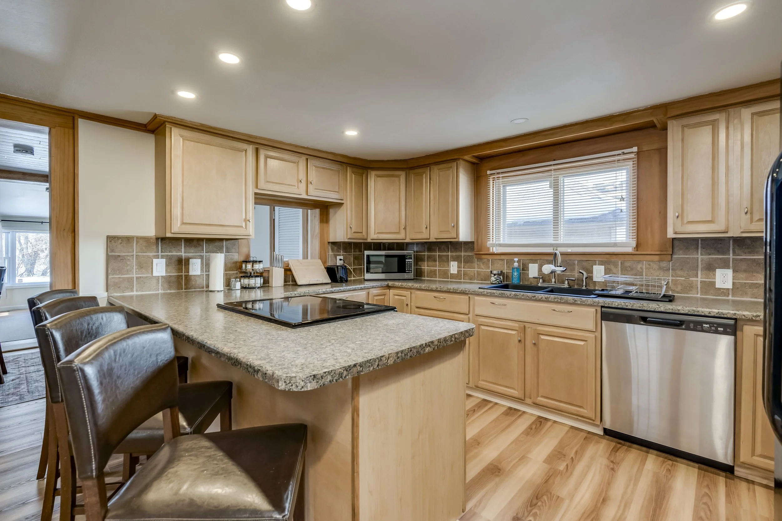 Kitchen with wood cabinets, granite countertops, a window above the sink, and stainless steel appliances.