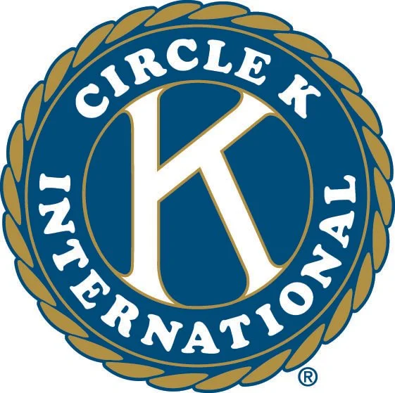 The logo of Circle K International, featuring a gold laurel wreath encircling a blue circle with a large white 'K' in the center, and the words 'CIRCLE K INTERNATIONAL' around the circle.