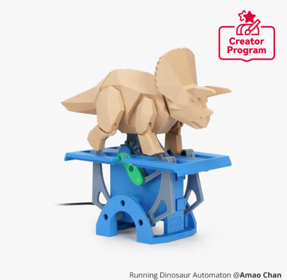 A wooden dinosaur model mounted on a blue robotic base, with a logo indicating a creator program.