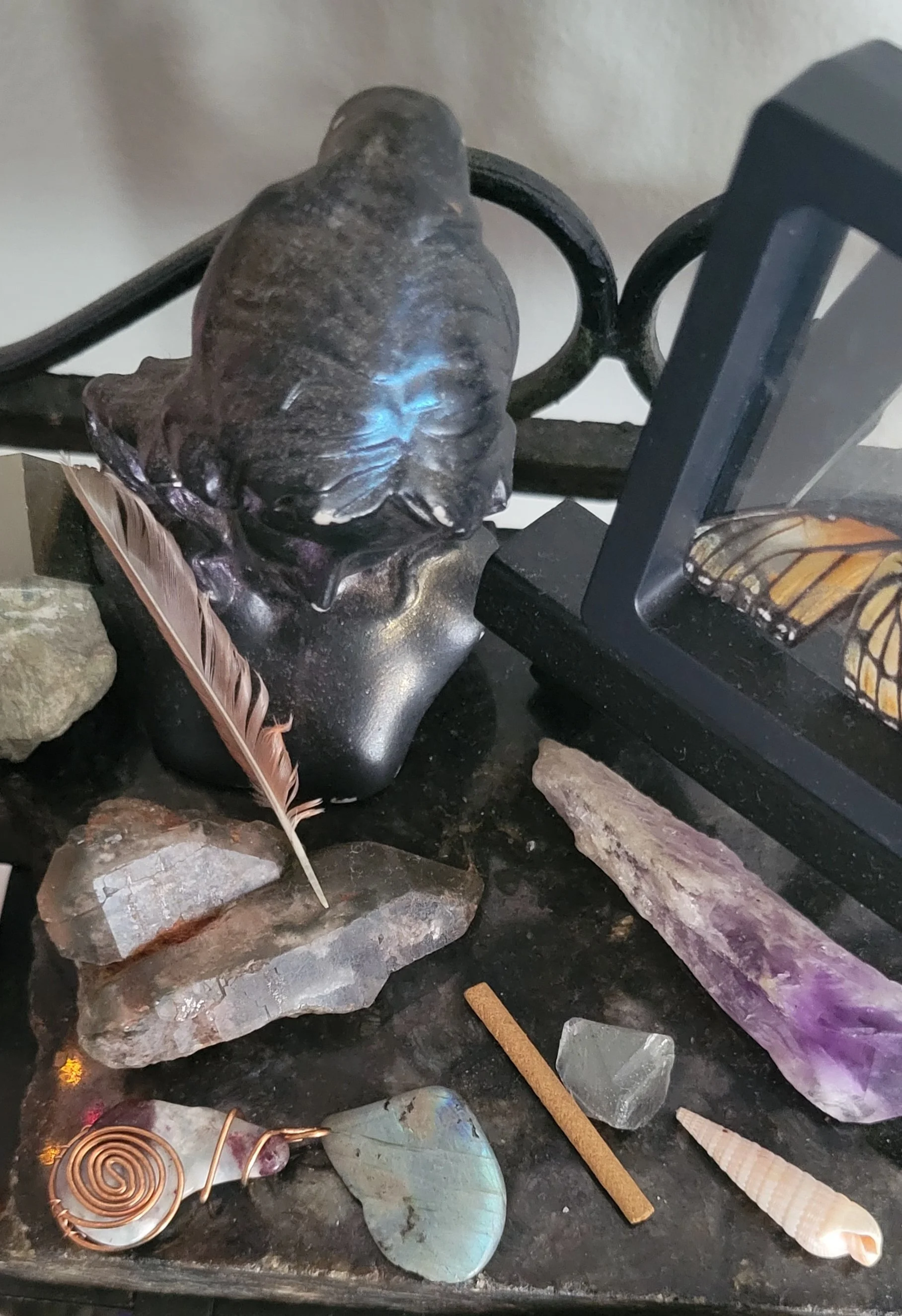 Bust and butterfly surrounded with crystals and a feather