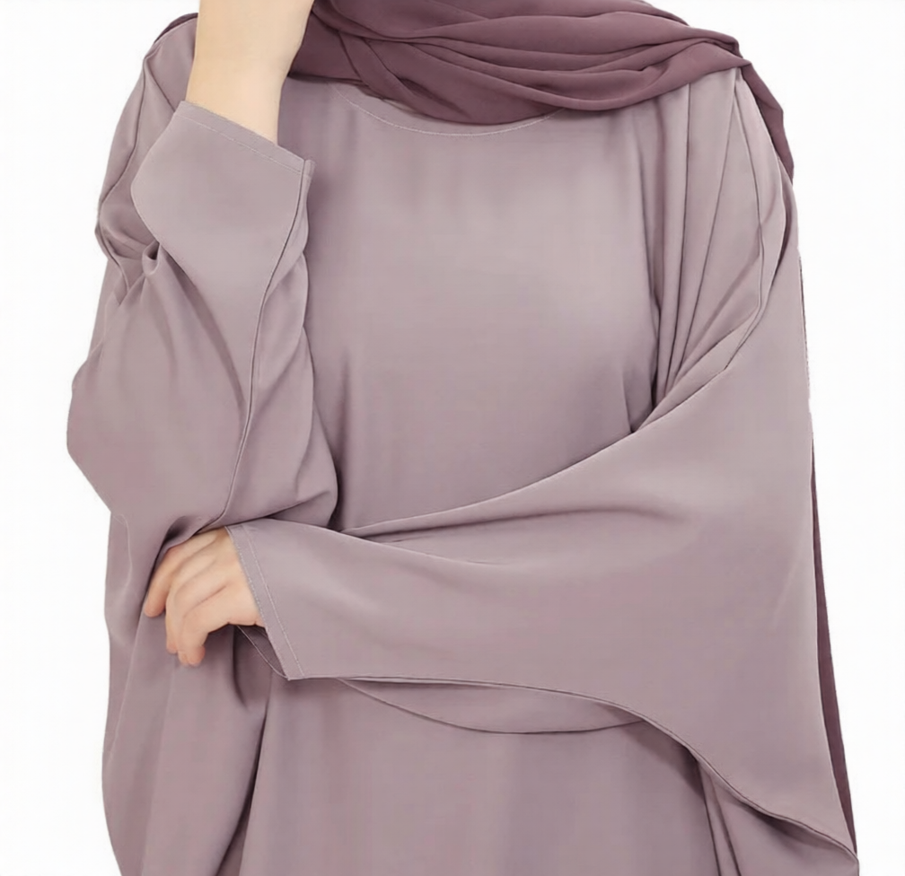 A woman wearing a mauve modest dress with long sleeves and a matching hijab.