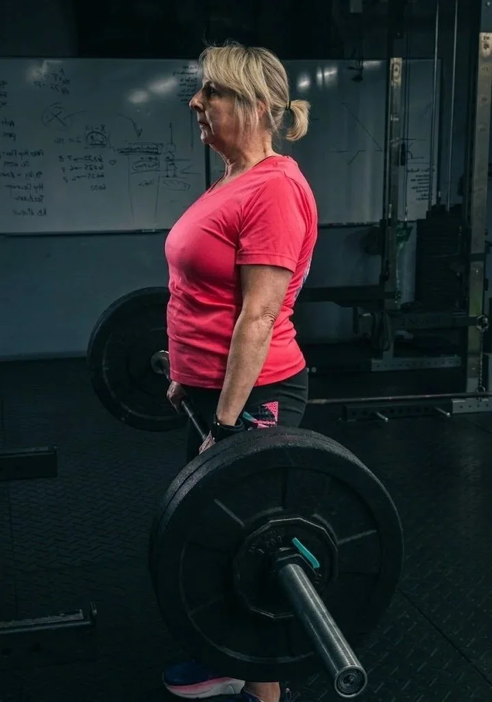 A client lifting a barbell at Iron House Gym
